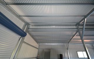 Roof framework of a double monopitch garage at Windella with corrugated roof cladding